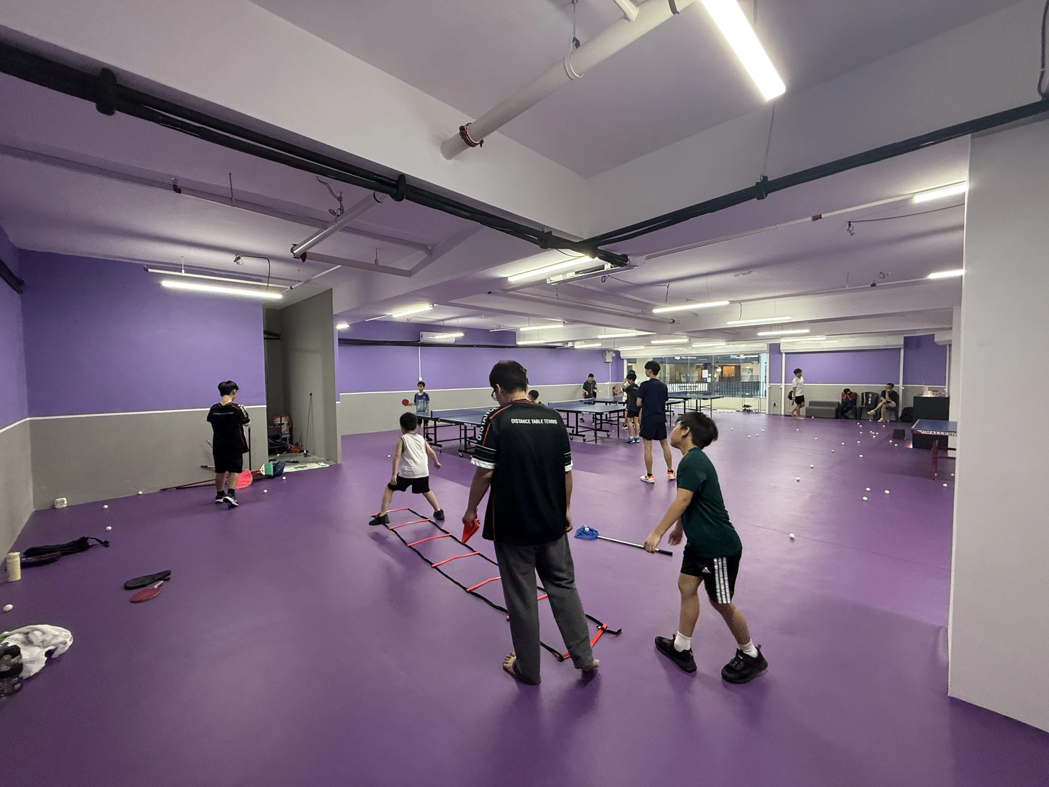 Coach guiding young DTB players through footwork practice